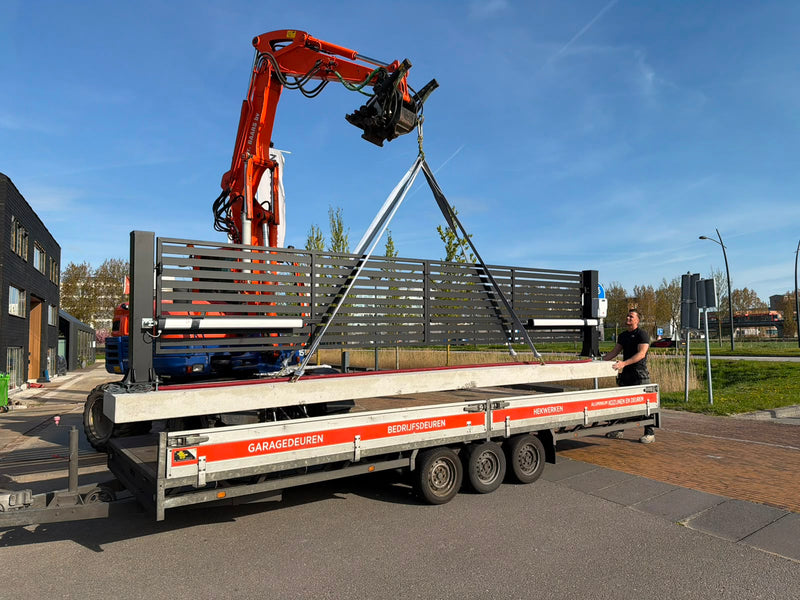 Monteurs plaatsen een schuifpoort op locatie