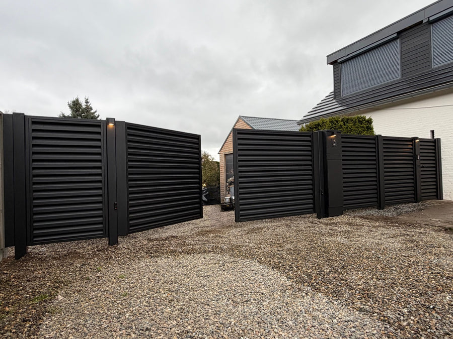 Zwarte draaipoort met spijlen voor een woning