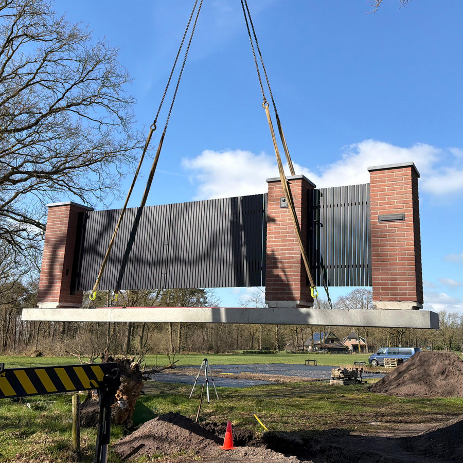 Moderne toegangspoort naast de oprit van een woning